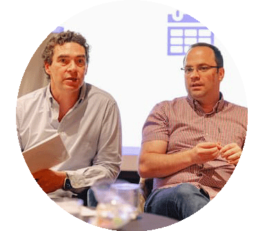 Two senior figures presenting at an open meeting